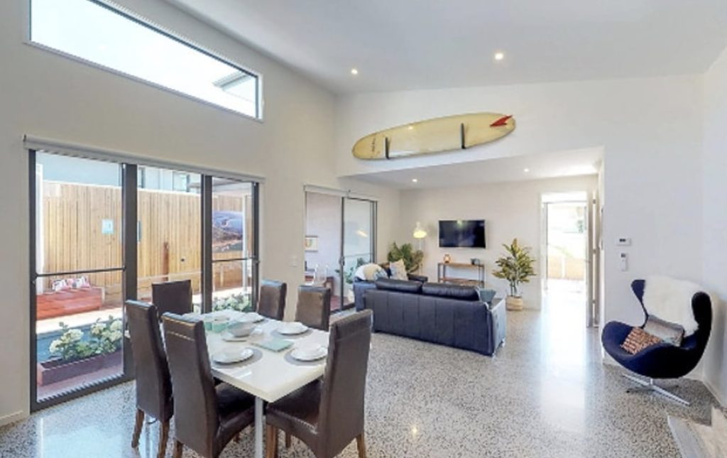 Bright, open-plan living and dining area of an accessible Destination Accessible home, with polished floors and wide door openings